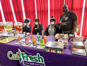 Image of Community Champion volunteers behind a CalFresh table display.